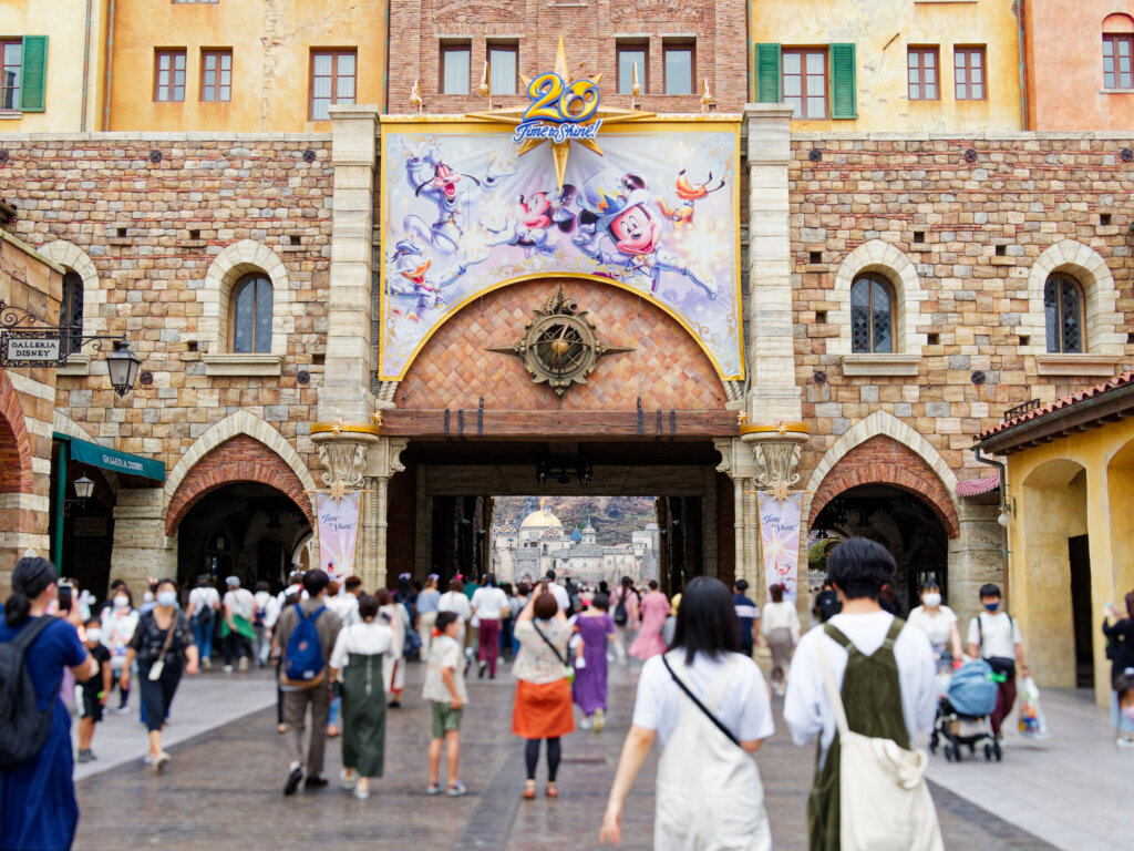 東京ディズニーシーのエントランスへ向かう人たち。20周年のバナーが掲げられている