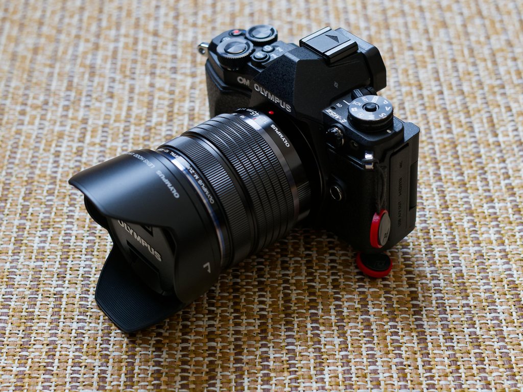 オリンパスOM-D E-M5 Mark IIにズームレンズとフードを付けて敷物に置いた状態